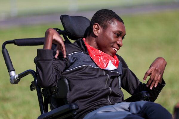 young man wheelchair red banda around